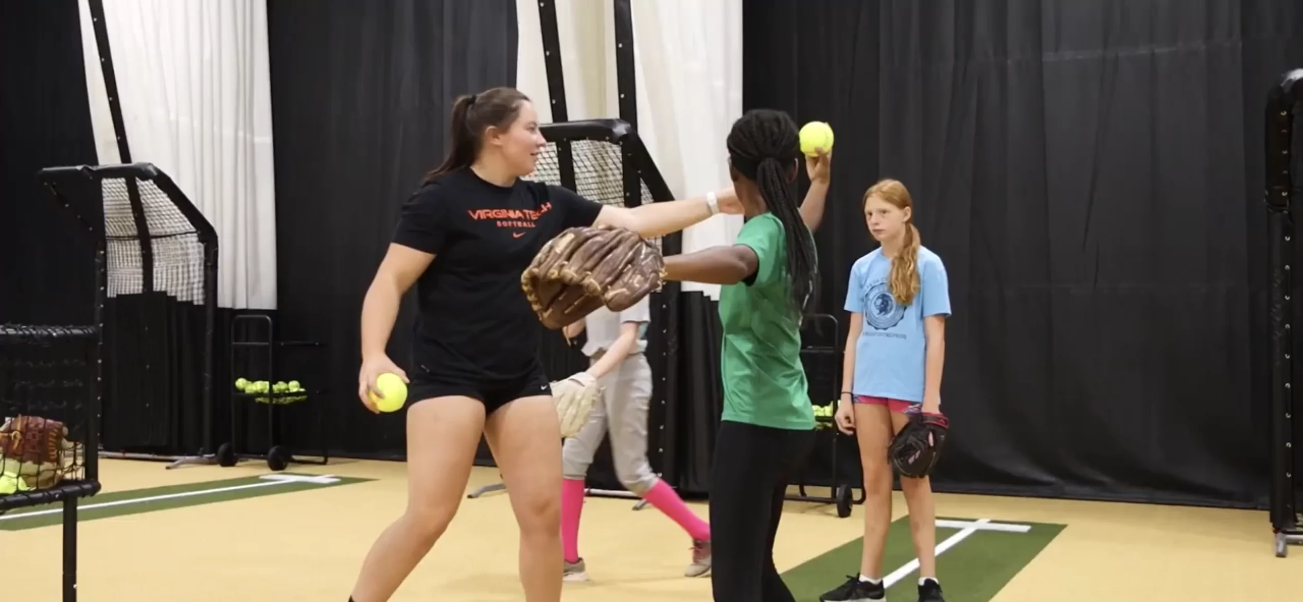 Female coach guiding child on pitching technique